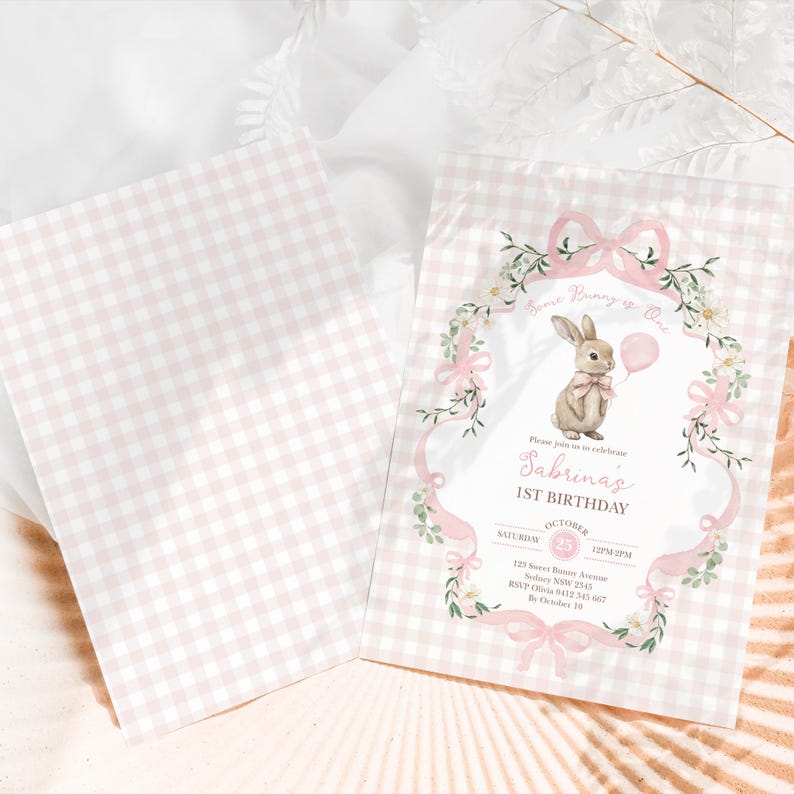Op de afbeelding: Twee roze en witte geruite uitnodigingen. E&eacute;n uitnodiging toont een konijn met een roze ballon, omringd door bloemaccenten en de tekst "Sabrina's 1st Birthday". De andere uitnodiging is leeg.