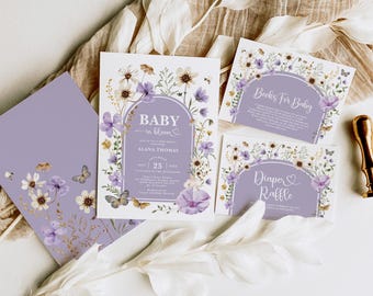 May include: Purple and white floral baby shower invitation with the text "Baby in Bloom" and "Alana Thomas".  The invitation also includes a date and time for the event.  There are two additional cards with the text "Books for Baby" and "Diaper Raffle".