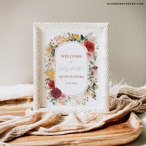 Peut inclure: Une pancarte d'accueil encadr&eacute;e de blanc avec un motif de couronne de fleurs. La pancarte indique "Bienvenue &agrave; Elizabeth's Quincea&ntilde;era 15.05.20XX".
