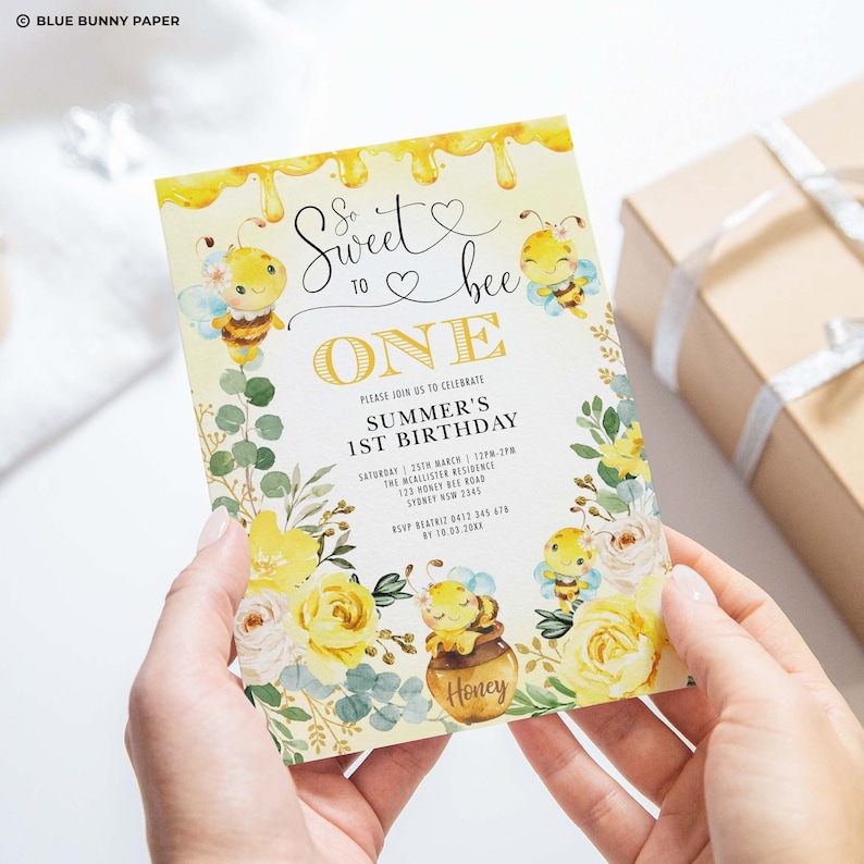 K&ouml;nnte beinhalten: Eine gelbe und wei&szlig;e Einladungskarte mit Bienen-Motiv. Die Karte sagt "So sweet to bee one" und hat einen Honigtopf mit einer Biene darauf. Der Text auf der Karte lautet "Bitte feiern Sie mit uns den 1. Geburtstag von Summer".