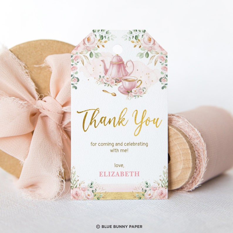 May include: A pink and gold thank you tag with a floral design and a teapot and teacup illustration. The text reads "Thank You for coming and celebrating with me! love, ELIZABETH".