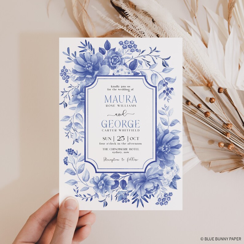 Puede incluir: Una invitaci&oacute;n de boda floral azul y blanca con un borde decorativo. La invitaci&oacute;n anuncia la boda de Maura Rose Williams y George Carter Whitfield el domingo 25 de octubre a las cuatro de la tarde en The Chinoiserie Hotel en Sydney, NSW. Recepci&oacute;n a continuaci&oacute;n.