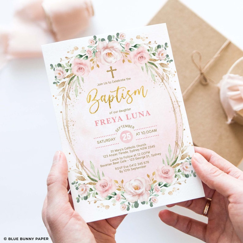 May include: A pink and gold baptism invitation featuring a floral wreath and the text "Join Us to Celebrate the Baptism of our daughter Freya Luna". The invitation includes the date, time, and location of the baptism ceremony, as well as the location of the reception.