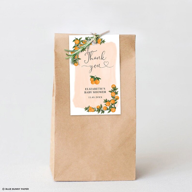 May include: Orange blossom and greenery border a peach-colored watercolor background on a thank you tag. The tag reads "Thank you" with a heart and "Elizabeth's Baby Shower 15.05.20XX".