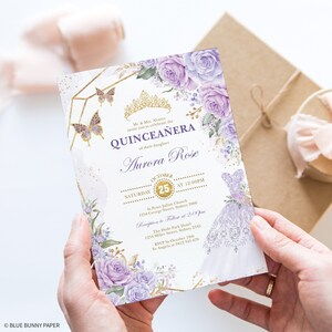 Pode incluir: Convite para uma Quincea&ntilde;era de cor roxa e dourada com um design floral e uma coroa dourada. O convite inclui a data, a hora e o local do evento. Tamb&eacute;m inclui o nome da aniversariante, Aurora Rose.