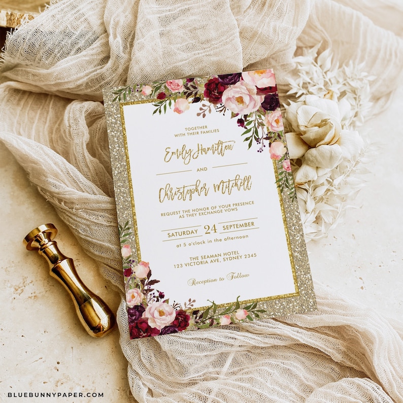 May include: A wedding invitation with a gold glitter background and floral accents. The invitation reads "Together with their families Emily Hamilton and Christopher Mitchell request the honor of your presence as they exchange vows Saturday 24 September at 5 o'clock in the afternoon. The Seaman Hotel 123 Victoria Ave, Sydney 2345 Reception to Follow."