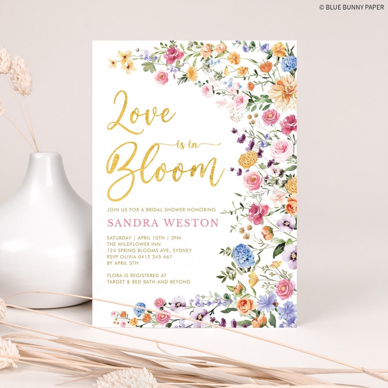 Peut inclure: Une invitation de f&ecirc;te pr&eacute;nuptiale florale avec un fond blanc et un design paillet&eacute; dor&eacute; qui dit "Love is in Bloom". L'invitation a une bordure rose et comprend le nom de la mari&eacute;e, la date, l'heure et le lieu de la f&ecirc;te. Le texte comprend &eacute;galement des informations sur le RSVP et l'endroit o&ugrave; la mari&eacute;e est inscrite.