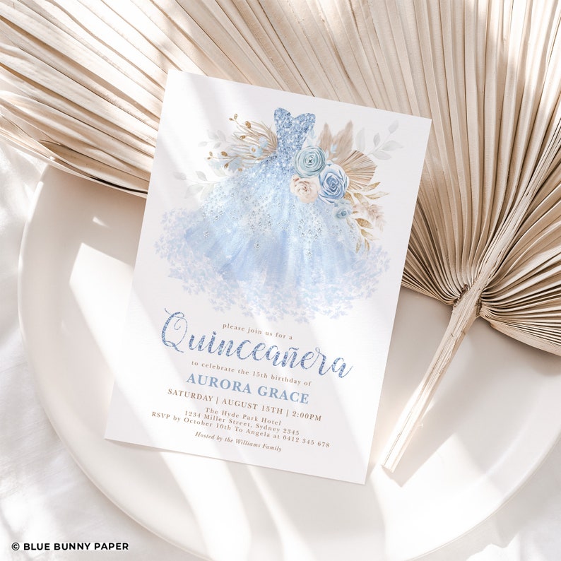 May include: A blue and gold Quincea&ntilde;era invitation with a sparkly blue dress illustration. The invitation text reads "Please join us for a Quincea&ntilde;era to celebrate the 15th birthday of AURORA GRACE SATURDAY | AUGUST 15TH | 2:00PM The Hyde Park Hotel 1234 Miller Street, Sydney 2345 RSVP by October 10th To Angela at 0412 345 678 Hosted by the Williams Family"