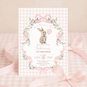 Op de afbeelding: Een roze en witte geruite uitnodigingskaart met een aquarel illustratie van een konijn met een roze ballon. De tekst luidt "Some Bunny is One" en "Sabrina's 1st Birthday". Roze strikken en bloemaccenten omlijsten de tekst.