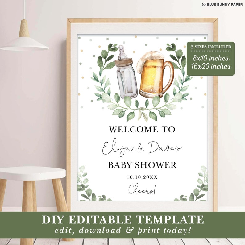 May include: A printable baby shower welcome sign with a green leafy wreath and a baby bottle and beer glass illustration. The text reads "Welcome to Eliza & Dave's Baby Shower 10.10.20XX Cheero!" and "DIY Editable Template edit, download & print today!"