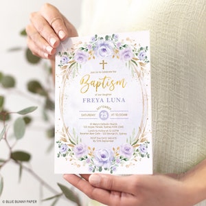 May include: A white and gold baptism invitation with purple flowers and a gold cross. The invitation reads "Join Us to Celebrate the Baptism of our daughter FREYA LUNA September 25 at 10:00AM St Mary's Catholic Church 123 Anzac Parade, Sydney NSW 2345 Lunch to Follow at 12:00PM Bavarian Beer Cafe - 123 George St, Sydney RSVP Eva 0412 345 678 By 10th September"