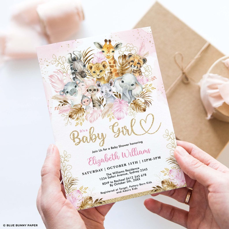 May include: Baby shower invitation featuring watercolor illustrations of safari animals, including a giraffe, lion, and elephant. The invitation has a pink and gold color scheme with the text "It's a Baby Girl" and event details.