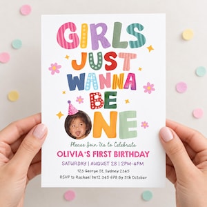 Puede incluir: Una tarjeta de invitación de cumpleaños rectangular con el texto colorido GIRLS JUST WANNA BE ONE. El diseño incluye una foto circular de un niño con un gorro de fiesta rosa, iconos de flores rosas y los detalles del primer cumpleaños de Olivia.