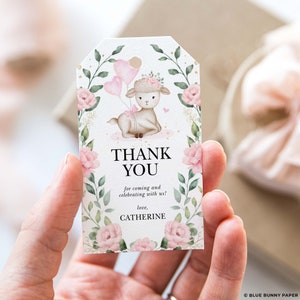 Op de afbeelding: Een bedankkaartje met een aquarel-illustratie van een schattig lammetje dat roze ballonnen vasthoudt. Het kaartje heeft een bloemige rand en de tekst "THANK YOU for coming and celebrating with us! love, CATHERINE".