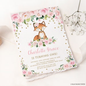 May include: A birthday invitation featuring a watercolor illustration of a fox surrounded by pink roses and greenery. The invitation includes the text "Charlotte Grace is turning one!" and event details.