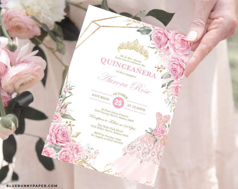 May include: A pink and gold Quincea&ntilde;era invitation with a floral design. The invitation features a crown, a pink dress, and the text "Quincea&ntilde;era" and "Aurora Rose".