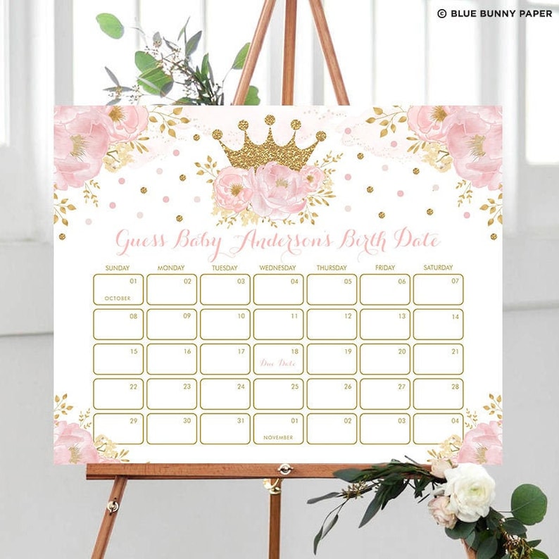 K&ouml;nnte beinhalten: Ein rosa-goldenes Babyparty-Spielschild mit Blumenmuster und einer Krone. Das Schild lautet "Errate Baby Andersons Geburtsdatum" und hat einen Kalender mit den Monaten Oktober und November.
