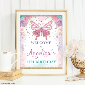 May include: A pink and gold welcome sign with a butterfly and flowers. The sign says "Welcome to Angelina's 5th Birthday".