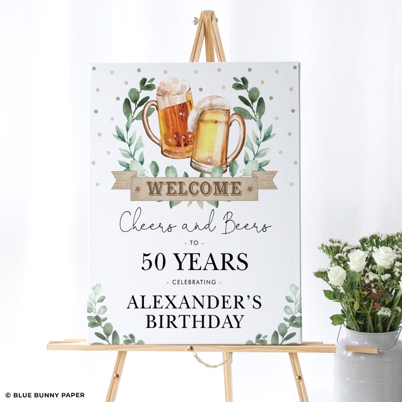 May include: Welcome sign with a white background, green leaves, and two beer mugs. The sign says "Welcome Cheers and Beers to 50 Years Celebrating Alexander's Birthday".
