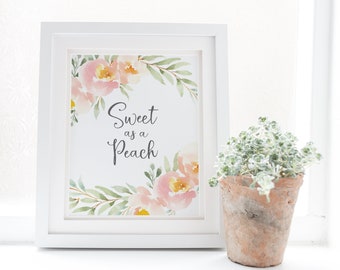 May include: A white framed print featuring a watercolour illustration of pink flowers and green leaves. The text "Sweet as a Peach" is written in grey cursive lettering.