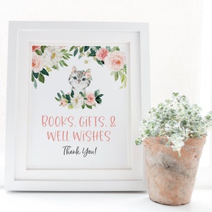 May include: White framed sign with a watercolor illustration of a cat with pink flowers. The sign reads "Books, Gifts, & Well Wishes Thank You!"