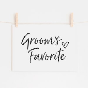 May include: A white card with black calligraphy that reads "Groom's Favorite" with a small heart symbol.