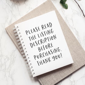 May include: A white notebook with a spiral binding, lying on a beige fabric surface. The notebook has the text "PLEASE READ THE LISTING DESCRIPTION BEFORE PURCHASING. THANK YOU!" written in black.