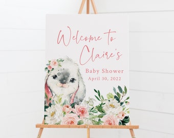 Könnte beinhalten: Willkommen zur Babyparty von Claire Schild mit einer Aquarell-Illustration eines Kaninchens mit einer rosa Blumenkrone, umgeben von rosa und weißen Blumen. Das Datum der Party ist der 30. April 2022.