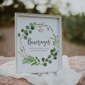 May include: A white framed sign with a green watercolor wreath and the text "Beverages" in black script. The sign also includes the text "Water, Pop, Beer, & Wine Please Help Yourself!"