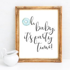 May include: A framed print with a blue donut and the text "Oh baby, it's party time!"