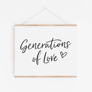 May include: A white framed print with black calligraphy that reads "Generations of Love" with a small heart symbol.