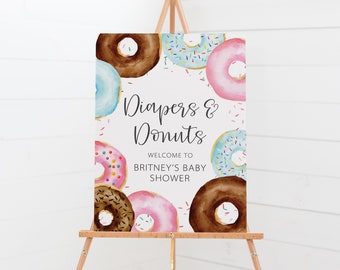 Puede incluir: Un cartel blanco con el texto "Diapers & Donuts" y "Bienvenido al baby shower de Britney". El cartel está decorado con donuts coloridos con chispas.