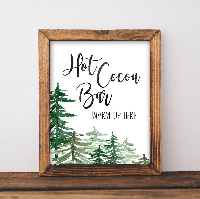 May include: A printable sign with a watercolor background of green trees. The sign says "Hot Cocoa Bar" and "Warm Up Here".