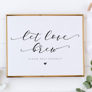 Op de afbeelding: Een wit bord met een gouden lijst, met de tekst "Let love brew" in zwarte cursieve letters. Onder de tekst staat "Please help yourself" in zwarte letters met een klein zwart hartje.