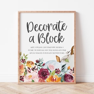 Peut inclure: Une affiche "Décorer un bloc" avec une illustration aquarelle d'une citrouille blanche avec des feuilles d'automne et des fleurs. L'affiche indique "Décorer un bloc" et "Écrivez un message, signez votre nom ou dessinez un dessin. Le bébé aura ces blocs avec vos pensées spéciales pour jouer pendant de nombreuses années."
