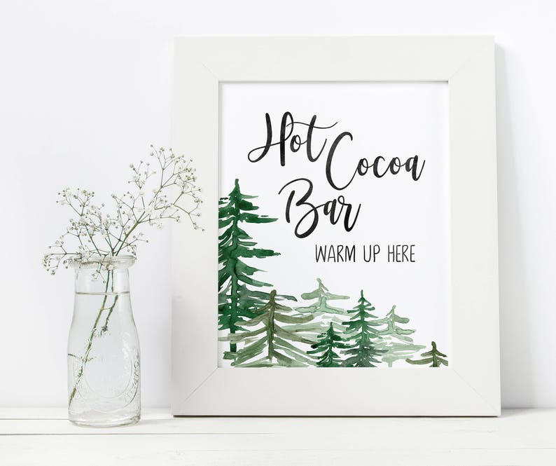 May include: A white framed printable sign with a watercolor illustration of green trees and the text "Hot Cocoa Bar Warm Up Here".