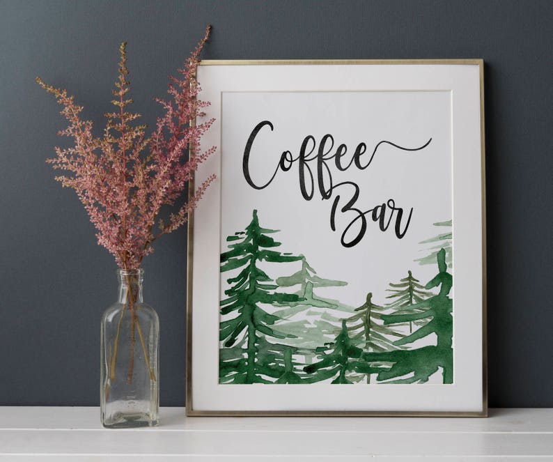 Puede incluir: Un cartel enmarcado en blanco con una ilustraci&oacute;n de acuarela de una escena de bosque. El cartel dice "Coffee Bar" en caligraf&iacute;a negra.