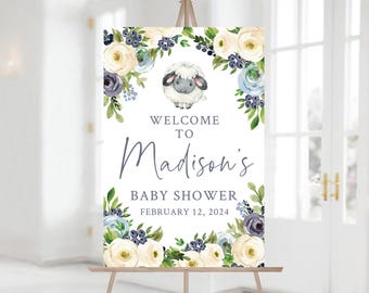 May include: Welcome to Madison's Baby Shower sign with a white background and floral border. The sign features a cute cartoon lamb and the text "Welcome to Madison's Baby Shower February 12, 2024".