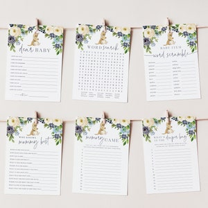 May include: Six printable baby shower game cards featuring a cute kangaroo illustration with floral accents in shades of blue and yellow. The games include "Dear Baby", "Word Search", "Baby Item Word Scramble", "Who Knows Mommy Best", "Memory Game", and "What's in the Diaper Bag".