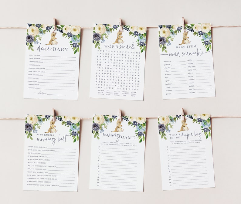 May include: Six printable baby shower game cards featuring a cute kangaroo illustration with floral accents in shades of blue and yellow. The games include "Dear Baby", "Word Search", "Baby Item Word Scramble", "Who Knows Mommy Best", "Memory Game", and "What's in the Diaper Bag".