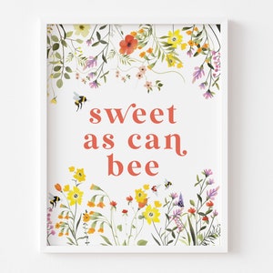 Puede incluir: Un fondo blanco con un borde floral y el texto "sweet as can bee" en rojo. Las flores son amarillas, rosas y naranjas con hojas verdes. También hay pequeñas abejas volando alrededor de las flores.