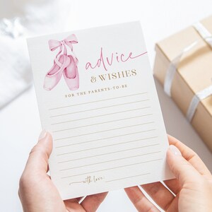 May include: A white card with pink ballet shoes and gold text that reads "advice & wishes for the parents-to-be" with a line at the bottom for a signature.