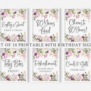 Könnte beinhalten: Set mit 10 druckbaren Schildern zum 80. Geburtstag mit einem floralen Design mit violetten, rosa und weißen Blumen. Die Schilder enthalten den Text "Eighty is Sweet", "80 Years Loved", "Cheers to 80 Years", "Tasty Bites", "Refreshments" und "Cards & Gifts".
