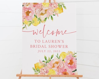 May include: Welcome sign for a bridal shower with pink and yellow watercolor flowers and lemons. The text reads "Welcome to Lauren's Bridal Shower July 22, 2023".