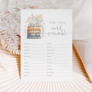May include: A baby shower game card with the text "BABY ITEM word scramble". The card features a watercolor illustration of a stack of books with flowers. The game includes a list of scrambled words.
