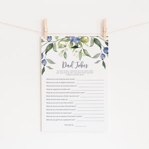 May include: A printable game card with a watercolor floral design featuring blue berries and green leaves. The card has the title "Dad Jokes" and includes a list of dad jokes with blank lines for players to fill in the punchlines.