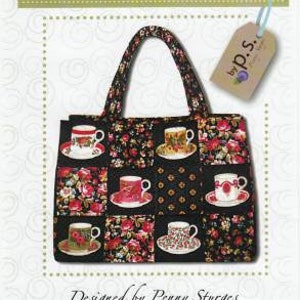 May include: A black and white fabric tote bag with a floral pattern and teacup designs. The bag has a black handle and a label that says "Quilts Illustrated by P.S.". The text "ps024 Chubby Charmer" is also visible on the image.