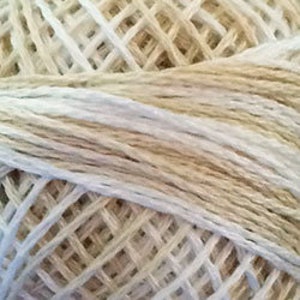 May include: A skein of white and beige yarn with a gradient effect. The yarn is made of natural fibers and has a soft, textured feel.