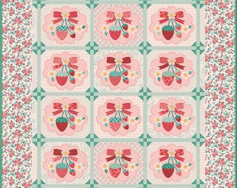 Könnte beinhalten: Eine gesteppte Decke mit einem sich wiederholenden Muster aus Erdbeeren und Schleifen auf hellrosa Hintergrund. Die Decke hat einen floralen Rand in Rosa- und Grüntönen. Das Design ist symmetrisch und hat eine Vintage-Ästhetik.