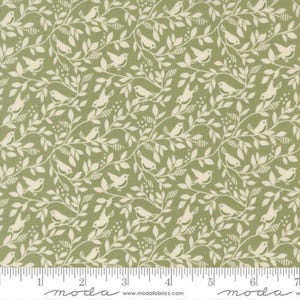 May include: A sage green fabric featuring a repeating pattern of cream-colored birds perched among leafy branches and small berries. A white ruler is visible at the bottom edge, showing measurements in inches from 0 to 7 inches for scale.